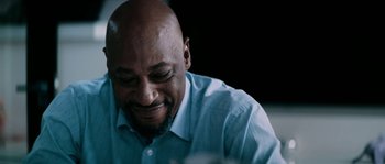 Movie still from “Avengement” (2019), directed by Jesse V. Johnson – A man with a beard and a blue shirt is smiling; Close Up shot, Low angle