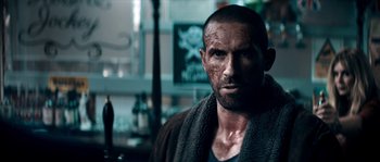Movie still from “Avengement” (2019), directed by Jesse V. Johnson – A person wearing a shirt and jacket; Close Up shot, Over the shoulder angle