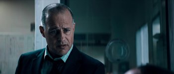 Movie still from “Avengement” (2019), directed by Jesse V. Johnson – A person wearing a suit and tie; Close Up shot, Low angle