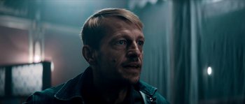 Movie still from “Avengement” (2019), directed by Jesse V. Johnson – A person wearing a jacket; Close Up shot, Low angle