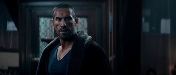 Movie still from “Avengement” (2019), directed by Jesse V. Johnson – A person with a beard wearing a jacket; Close Up shot, Over the shoulder angle