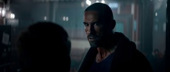 Movie still from “Avengement” (2019), directed by Jesse V. Johnson – A person with a beard looking at the camera; Close Up shot, Over the shoulder angle