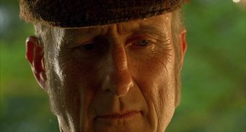 Movie still from “Babe” (1995), directed by Chris Noonan – An older man with a hat on his head looking at the camera; Extreme Close Up shot, Low angle