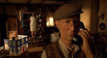 Movie still from “Babe” (1995), directed by Chris Noonan – An older man talking on a phone while wearing a hat; Close Up shot, Low angle