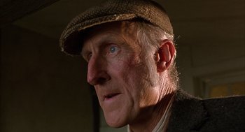 Movie still from “Babe” (1995), directed by Chris Noonan – An older man wearing a brown hat and a jacket; Close Up shot, Low angle