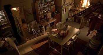 Movie still from “Babe” (1995), directed by Chris Noonan – A table and chairs in a room with a stove and a microwave; Extreme Wide shot, High angle
