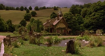 Movie still from “Babe” (1995), directed by Chris Noonan – An old church sits in the middle of a lush green field; Extreme Wide shot, High angle