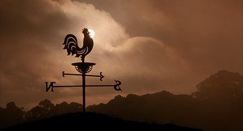 Movie still from “Babe” (1995), directed by Chris Noonan – A weather vane in the shape of a rooster on top of a hill; Extreme Wide shot, Low angle