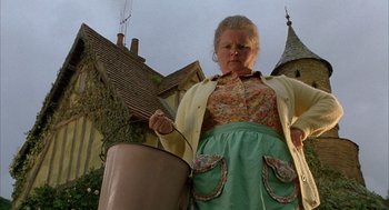 Movie still from “Babe” (1995), directed by Chris Noonan – An older woman holding a pot in front of a house; Medium shot, Low angle