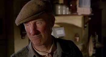 Movie still from “Babe” (1995), directed by Chris Noonan – An older man wearing a brown hat and glasses; Close Up shot, Low angle
