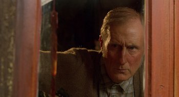 Movie still from “Babe” (1995), directed by Chris Noonan – An older man holding a knife in his hand; Close Up shot, Low angle
