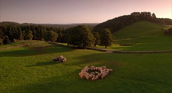 Movie still from “Babe” (1995), directed by Chris Noonan – A herd of sheep standing on top of a lush green field; Extreme Wide shot, High angle