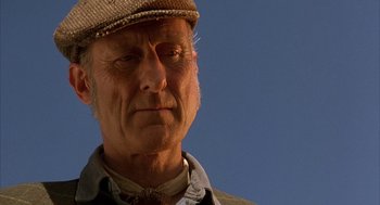 Movie still from “Babe” (1995), directed by Chris Noonan – An older man wearing a hat and a jacket; Close Up shot, Low angle