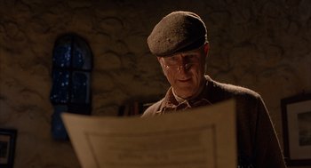 Movie still from “Babe” (1995), directed by Chris Noonan – An old man wearing glasses and a hat looking at a paper; Close Up shot, Low angle