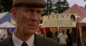 Movie still from “Babe” (1995), directed by Chris Noonan – An older man wearing a hat and a tie; Close Up shot, Over the shoulder angle