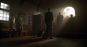 Movie still from “Babe” (1995), directed by Chris Noonan – A group of people standing in a room with a dog; Wide shot, Low angle