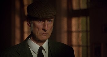 Movie still from “Babe” (1995), directed by Chris Noonan – A person wearing a suit and a hat; Close Up shot, Over the shoulder angle