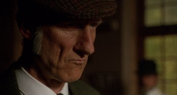 Movie still from “Babe” (1995), directed by Chris Noonan – An older man wearing a hat and a tie; Close Up shot, Over the shoulder angle