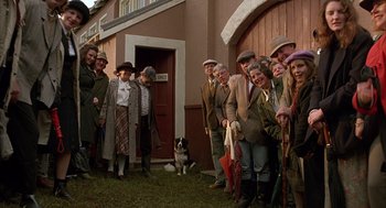 Movie still from “Babe” (1995), directed by Chris Noonan – A group of people standing in front of a building; Wide shot, High angle