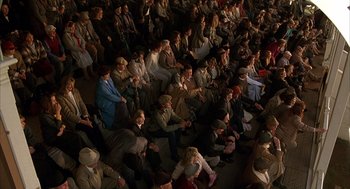 Movie still from “Babe” (1995), directed by Chris Noonan – A large group of people sitting on the ground; Wide shot, High angle