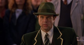 Movie still from “Babe” (1995), directed by Chris Noonan – A man wearing a hat and a green suit; Close Up shot, Over the shoulder angle