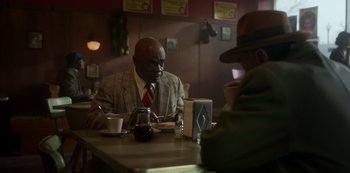 Movie still from “Fargo” (2014), created by Noah Hawley – A man sitting at a table in a restaurant; Medium shot, Over the shoulder angle