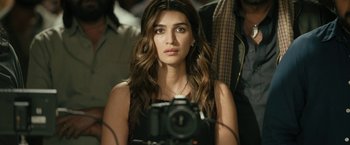 A beautiful young lady taking a picture with a camera