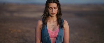 A beautiful young lady with long brown hair wearing a pink top