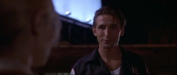 Movie still from “Backdraft” (1991), directed by Ron Howard – A person wearing a black shirt; Close Up shot, Low angle