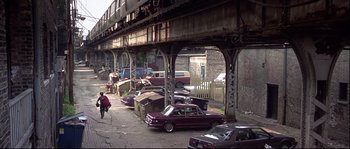 Movie still from “Backdraft” (1991), directed by Ron Howard – An old car is parked under a bridge; Extreme Wide shot, High angle