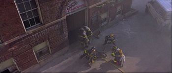 Movie still from “Backdraft” (1991), directed by Ron Howard – A group of firemen working on a fire truck; Extreme Wide shot, High angle
