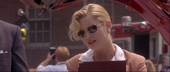 Movie still from “Backdraft” (1991), directed by Ron Howard – A woman in sunglasses holding an umbrella in the street; Close Up shot, Low angle