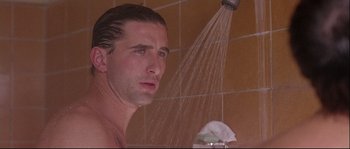 Movie still from “Backdraft” (1991), directed by Ron Howard – A man is taking a shower in the bathroom; Close Up shot, Low angle