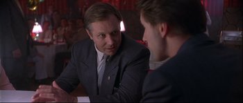 Movie still from “Backdraft” (1991), directed by Ron Howard – A man in a business suit talking to another man in a business suit; Close Up shot, Over the shoulder angle