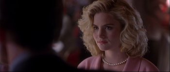 Movie still from “Backdraft” (1991), directed by Ron Howard – A woman with blonde curly hair wearing a pearl necklace; Close Up shot, Over the shoulder angle