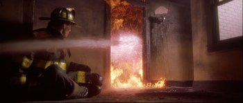 Movie still from “Backdraft” (1991), directed by Ron Howard – A fire in the door of a building; Wide shot, Low angle