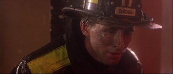 Movie still from “Backdraft” (1991), directed by Ron Howard – A person wearing a helmet; Close Up shot, Low angle