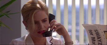 Movie still from “Backdraft” (1991), directed by Ron Howard – A woman talking on a phone while sitting in a chair; Close Up shot, Low angle