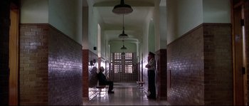 Movie still from “Backdraft” (1991), directed by Ron Howard – Two men are sitting in a hallway of a building; Wide shot, High angle