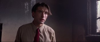 Movie still from “Backdraft” (1991), directed by Ron Howard – A man in a tan shirt and a red tie; Close Up shot, Low angle