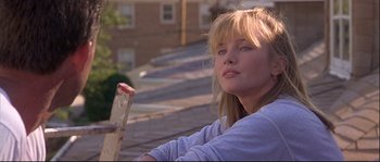 Movie still from “Backdraft” (1991), directed by Ron Howard – A young woman sitting on top of a building; Close Up shot, Low angle