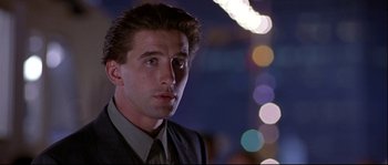Movie still from “Backdraft” (1991), directed by Ron Howard – A man in a suit and tie in front of lights; Close Up shot, Low angle