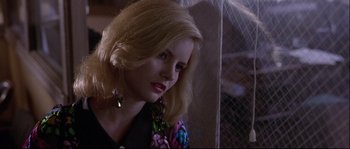 Movie still from “Backdraft” (1991), directed by Ron Howard – A woman with blonde hair wearing a black top; Close Up shot, Over the shoulder angle