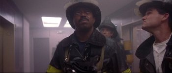 Movie still from “Backdraft” (1991), directed by Ron Howard – A man in a fireman's uniform with a helmet on his head; Close Up shot, Low angle
