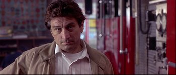 Movie still from “Backdraft” (1991), directed by Ron Howard – A person wearing a shirt and jacket; Close Up shot, Over the shoulder angle