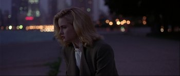 Movie still from “Backdraft” (1991), directed by Ron Howard – A woman with blonde hair sitting on the ground; Medium shot, Over the shoulder angle