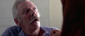 Movie still from “Backdraft” (1991), directed by Ron Howard – An older man with a mustache is looking up; Close Up shot, Low angle