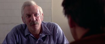 Movie still from “Backdraft” (1991), directed by Ron Howard – An older man is talking to a younger man; Close Up shot, Over the shoulder angle