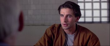 Movie still from “Backdraft” (1991), directed by Ron Howard – A person sitting in a room; Close Up shot, Over the shoulder angle