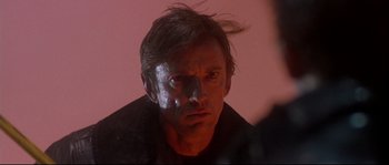 Movie still from “Backdraft” (1991), directed by Ron Howard – A person wearing a black shirt; Close Up shot, Over the shoulder angle